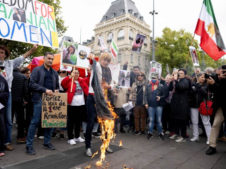 A woman burns headscarves during a demonstration in support of Kurdish Iranian woman Mahsa Amini during a protest on Sunday on Place de la Republique in Paris, following Amini's death in Iran.
Stefano Rellandini/AFP via Getty Images