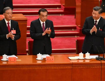 China's President Xi Jinping (right) applauds beside Premier Li Keqiang (center) and Politburo Standing Committee member Wang Yang during the closing ceremony of the 20th Chinese Communist Party's Congress in Beijing on Saturday. (Noel Celis/AFP via Getty Images)