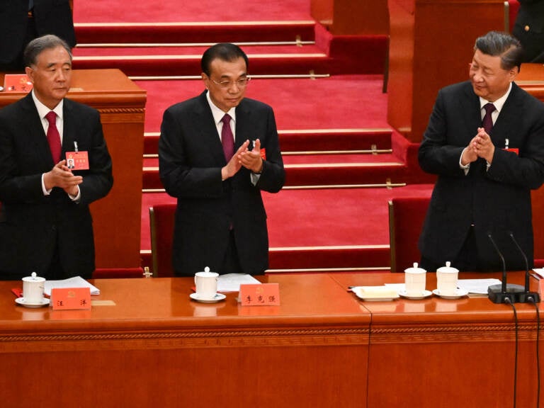 China's President Xi Jinping (right) applauds beside Premier Li Keqiang (center) and Politburo Standing Committee member Wang Yang during the closing ceremony of the 20th Chinese Communist Party's Congress in Beijing on Saturday. (Noel Celis/AFP via Getty Images)