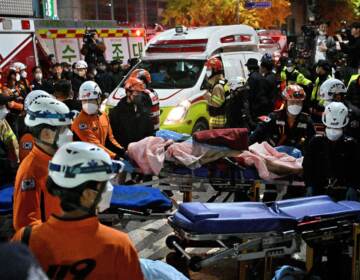 Medical staff transport a victim of a Halloween crush on a stretcher in the district of Itaewon in Seoul on October 30, 2022. (Jung Yeon-Je/AFP via Getty Images)