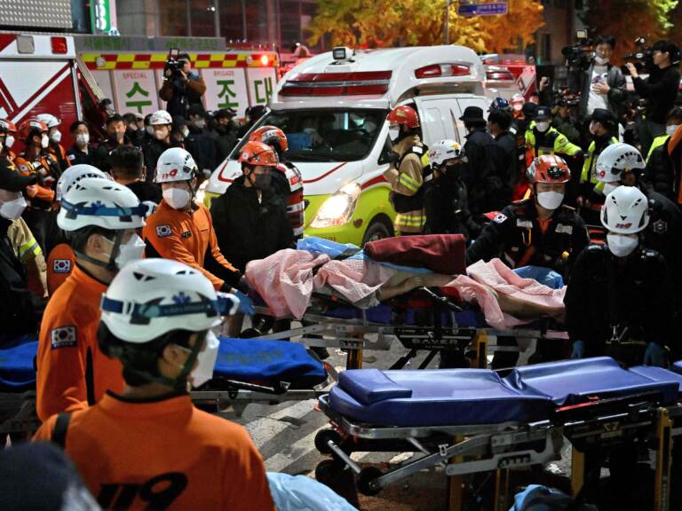 Medical staff transport a victim of a Halloween crush on a stretcher in the district of Itaewon in Seoul on October 30, 2022. (Jung Yeon-Je/AFP via Getty Images)