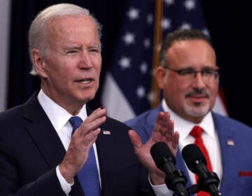 President Joe Biden speaks on the student debt relief plan as Secretary of Education Miguel Cardona (right) listens