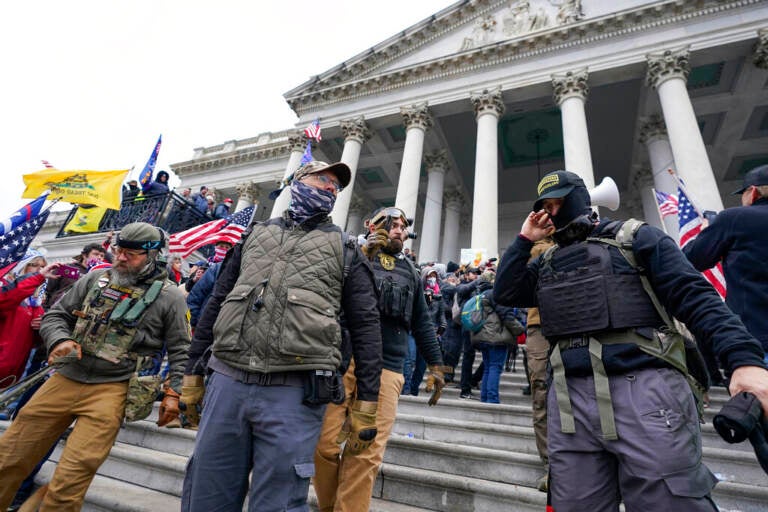People stand in front of the U.S. Capitol building during the Capitol riot on Jan. 6, 2021.