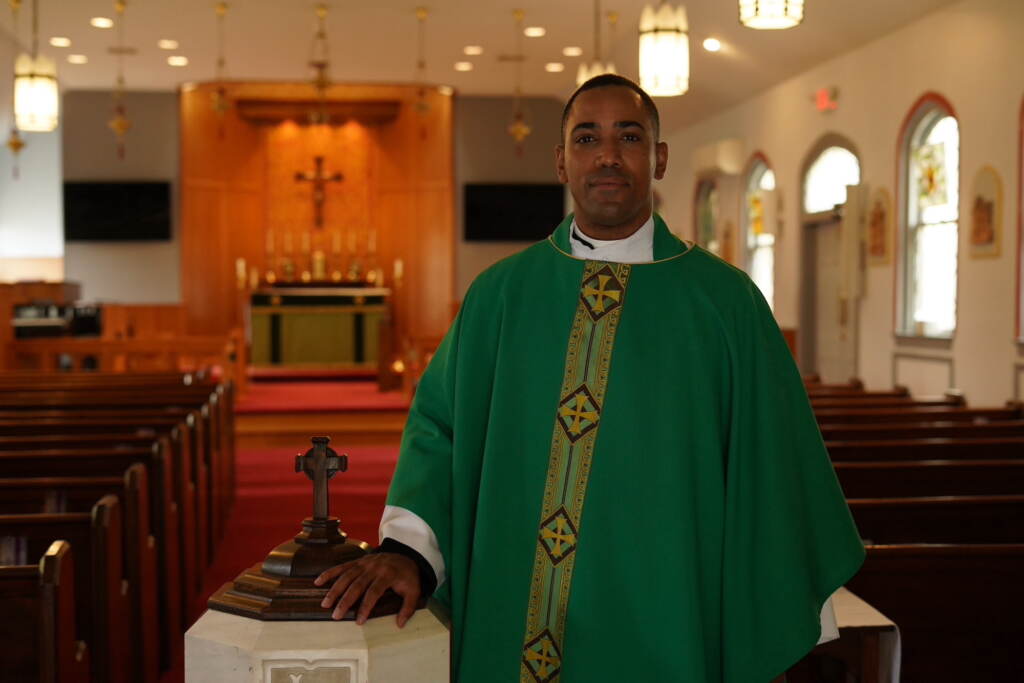 A reverend stands at the front of a church.