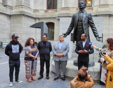 People gather around the Octavius Catto statue outside of City Hall.