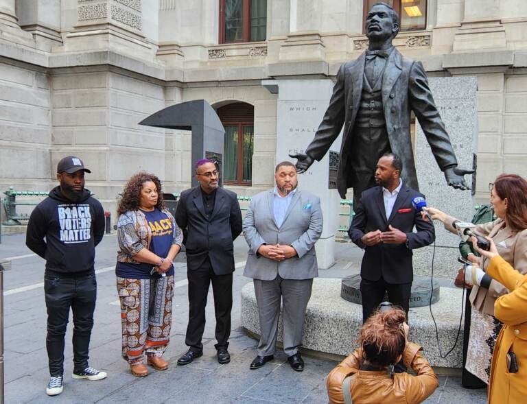 People gather around the Octavius Catto statue outside of City Hall.