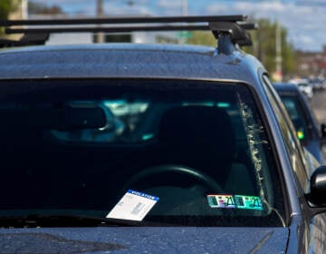 A parking ticket sits on the windowshield of a car.