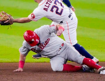Phillies player Kyle Schwarber slides into second base.