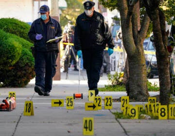 Investigators work the scene where multiple people were shot including police officers when a SWAT team attempted to serve a homicide warrant in Philadelphia, Wednesday, Oct. 12, 2022. (AP Photo/Matt Rourke)