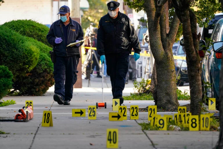 Investigators work the scene where multiple people were shot including police officers when a SWAT team attempted to serve a homicide warrant in Philadelphia, Wednesday, Oct. 12, 2022. (AP Photo/Matt Rourke)