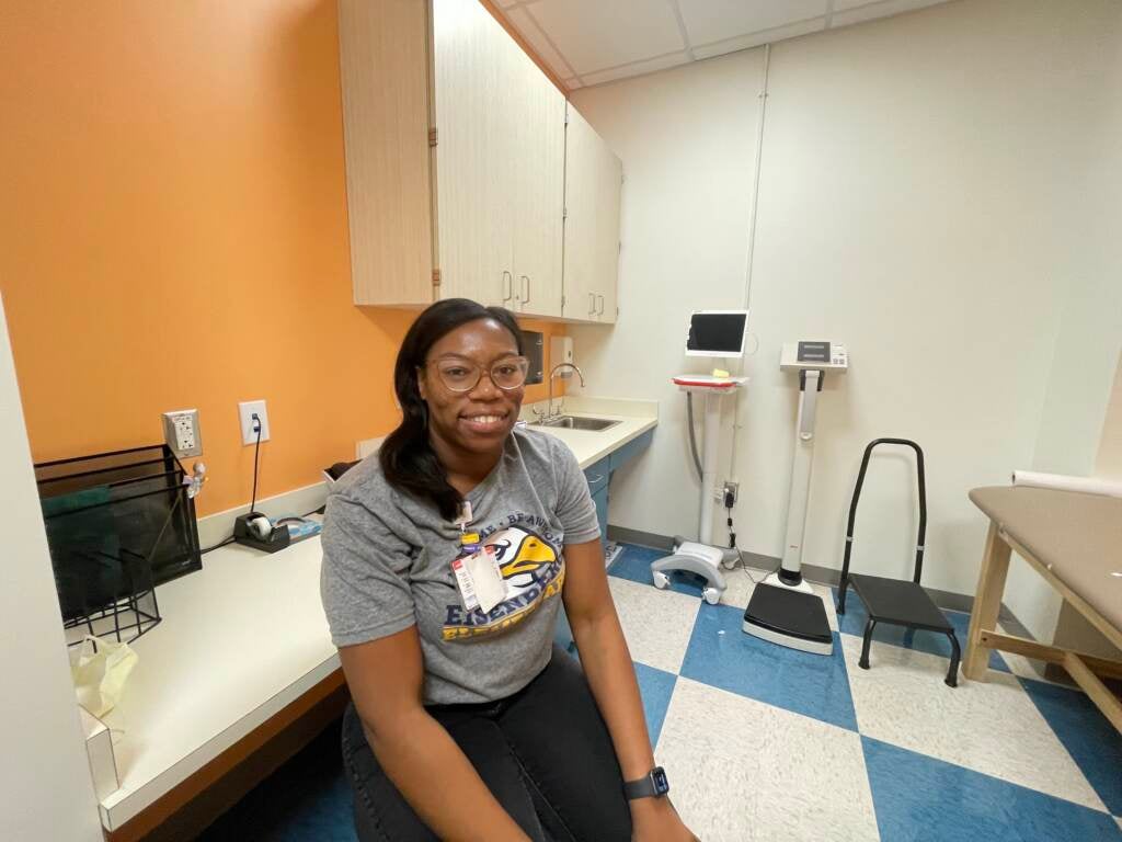 A nurse practitioner sits in a medical office.