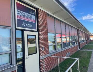 The exterior of a school is visible on a sunny day.