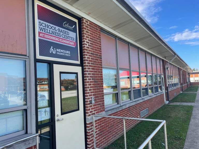 The exterior of a school is visible on a sunny day.