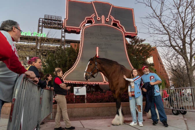 Joe Ladik and his daughter Teresa pose with Budweiser horse Rocco outside Citizens Bank Park before game 3 of the World Series on November 1, 2022. (Kimberly Paynter/WHYY)