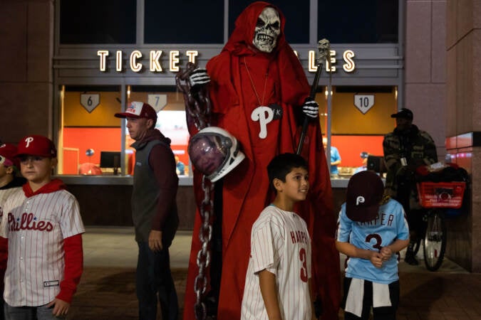 A red reaper holds the head of Texas Senator Ted Cruz outside game 3 of the World Series at Citizens Bank Park on November 1, 2022. (Kimberly Paynter/WHYY)