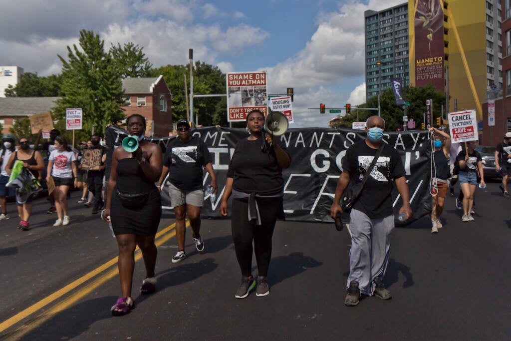 People walk down the street in a protest.