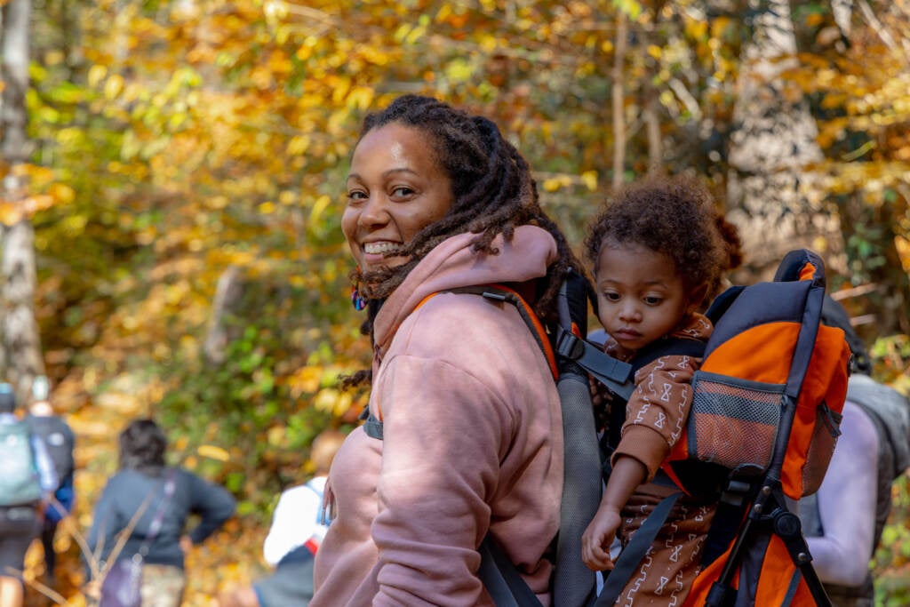 A mother poses with her child in the woods.