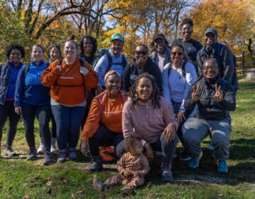 A group of people pose for a photo on a beautiful fall day.