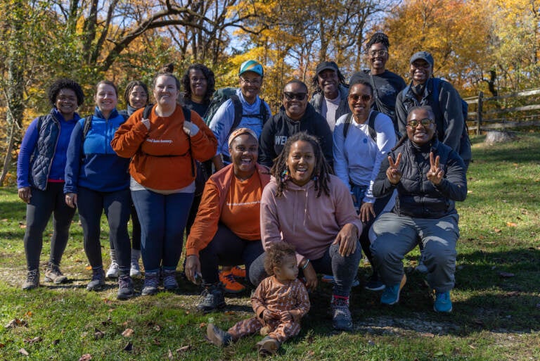 A group of people pose for a photo on a beautiful fall day.