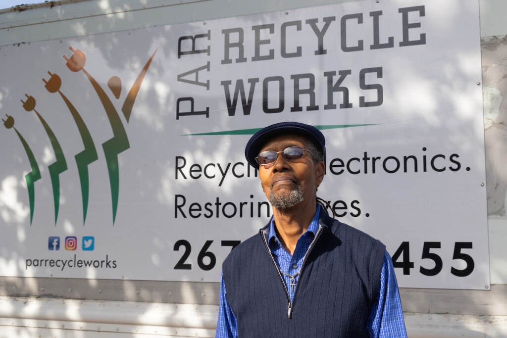A man stands in front of a sign that reads PAR Recycle Works.