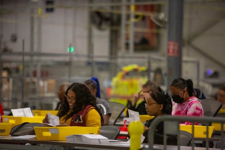 File photo: Flattening the mail-in ballout after it is removed from its secrecy envelope is a necessary process that is done by hand so that ballots can be scanned  properly at the Philadelphia County Ballot Processing Center  on November 8th 2022. Emily Cohen For WHYY