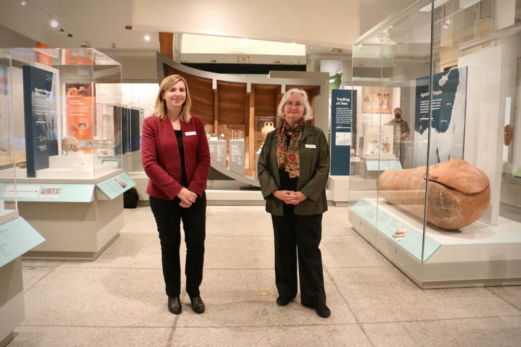 Two curators stand in the middle of an exhibition.