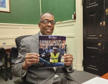 Council President Darrell Clarke holds up an information pamphlet for new jobs. (Tom MacDonald/WHYY)