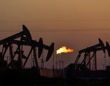 A flare burns off methane and other hydrocarbons as oil pumpjacks operate in the Permian Basin in Midland, Texas, Tuesday, Oct. 12, 2021. Massive amounts of methane are venting into the atmosphere from oil and gas operations across the Permian Basin, new aerial surveys show. The emission endanger U.S. targets for curbing climate change.  (AP Photo/David Goldman)