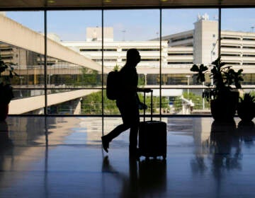 A traveler moves through the Philadelphia International Airport ahead of the Independence Day holiday weekend in Philadelphia, Friday, July 1, 2022. (AP Photo/Matt Rourke, File)