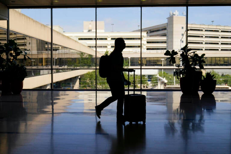 A traveler moves through the Philadelphia International Airport ahead of the Independence Day holiday weekend in Philadelphia, Friday, July 1, 2022. (AP Photo/Matt Rourke, File)