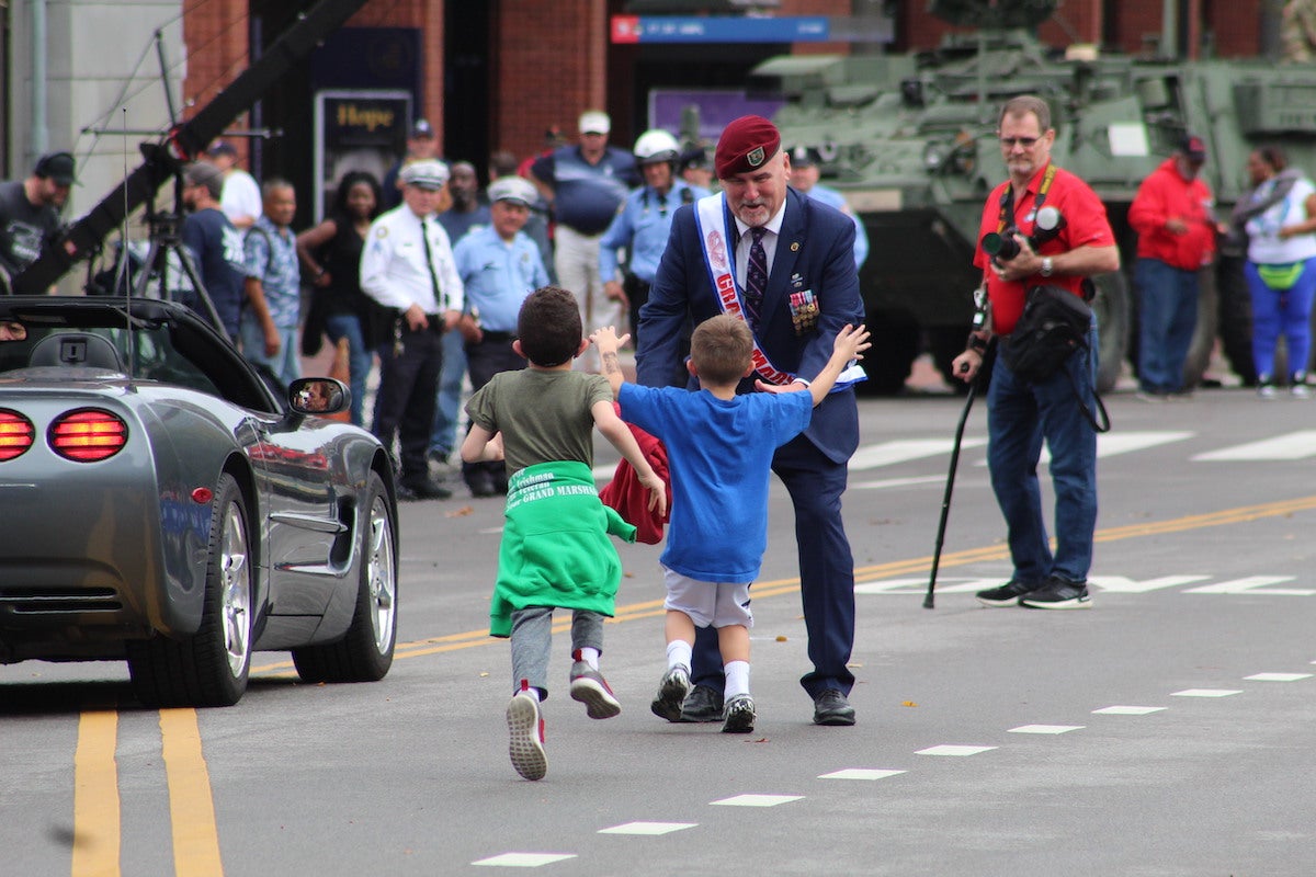 Judge Patrick Dugan served as the parade's Grand Marshal and was embracing some family members following his introduction. (Cory Sharber/WHYY)