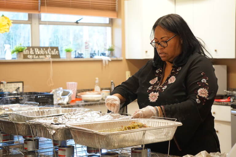 Board member Jessica Whitfield serves Thanksgiving dishes at the POMC pre-Thanksgiving dinner. (Sam Searles/WHYY)
