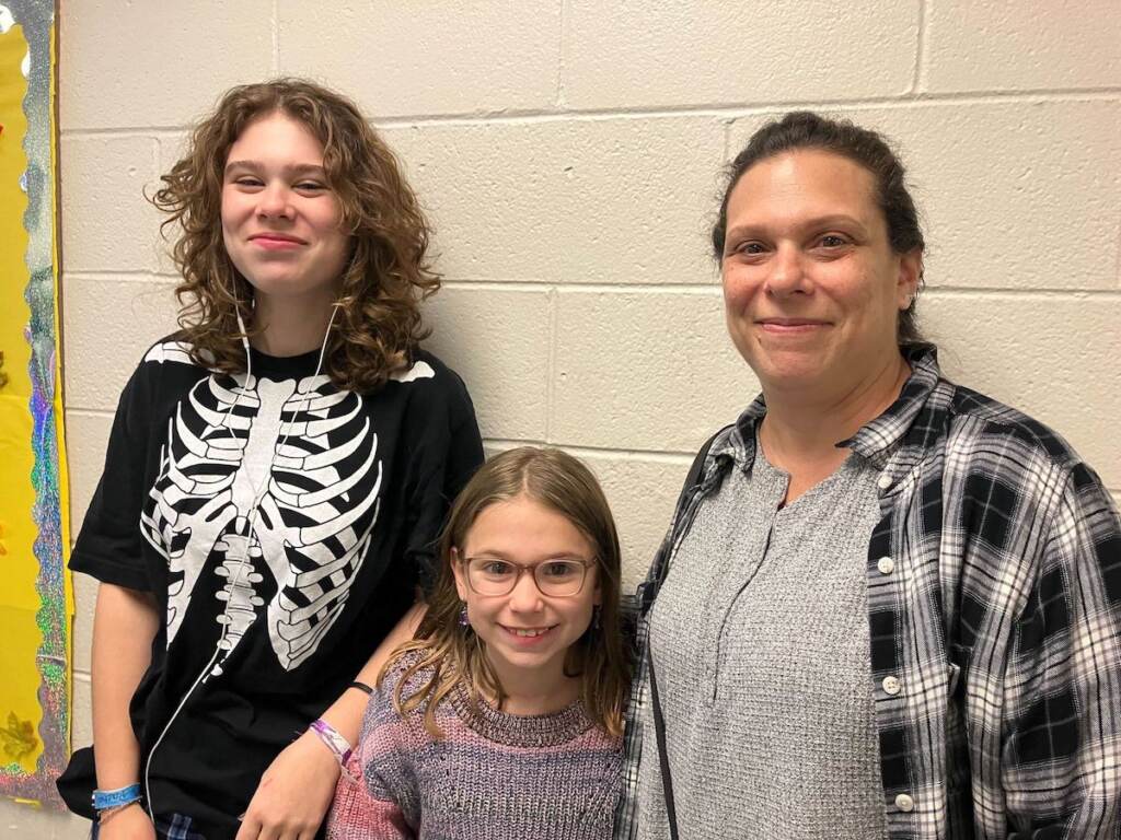 A woman poses with her daughters.