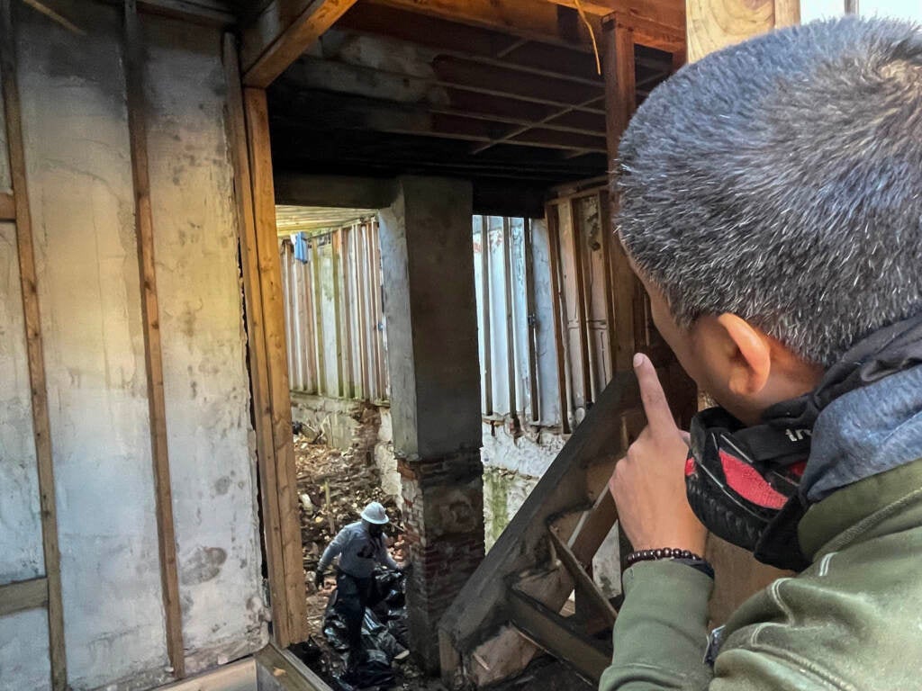 Contractor Miguel Dani peers into the gutted interior of the home now being renovated on Lombard Street.