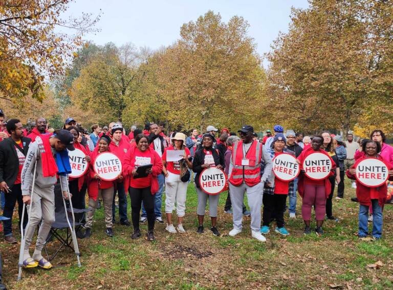 A group of people wearing red T-shirts pose with signs that read, 