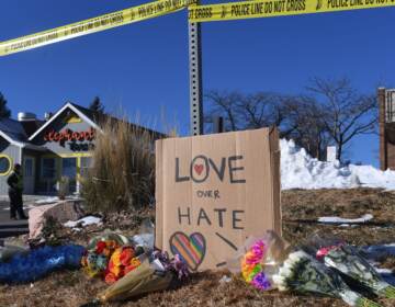 Bouquets of flowers and a sign reading ''Love Over Hate'' are left near Club Q