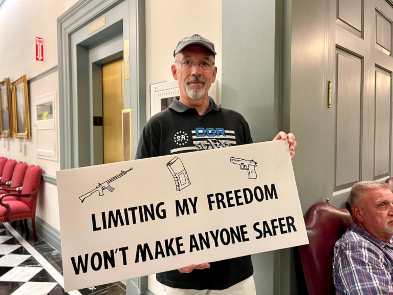 A man holds a sign that reads, 