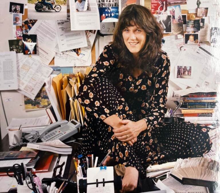 Marty Moss-Coane is seen sitting on a desk in her office