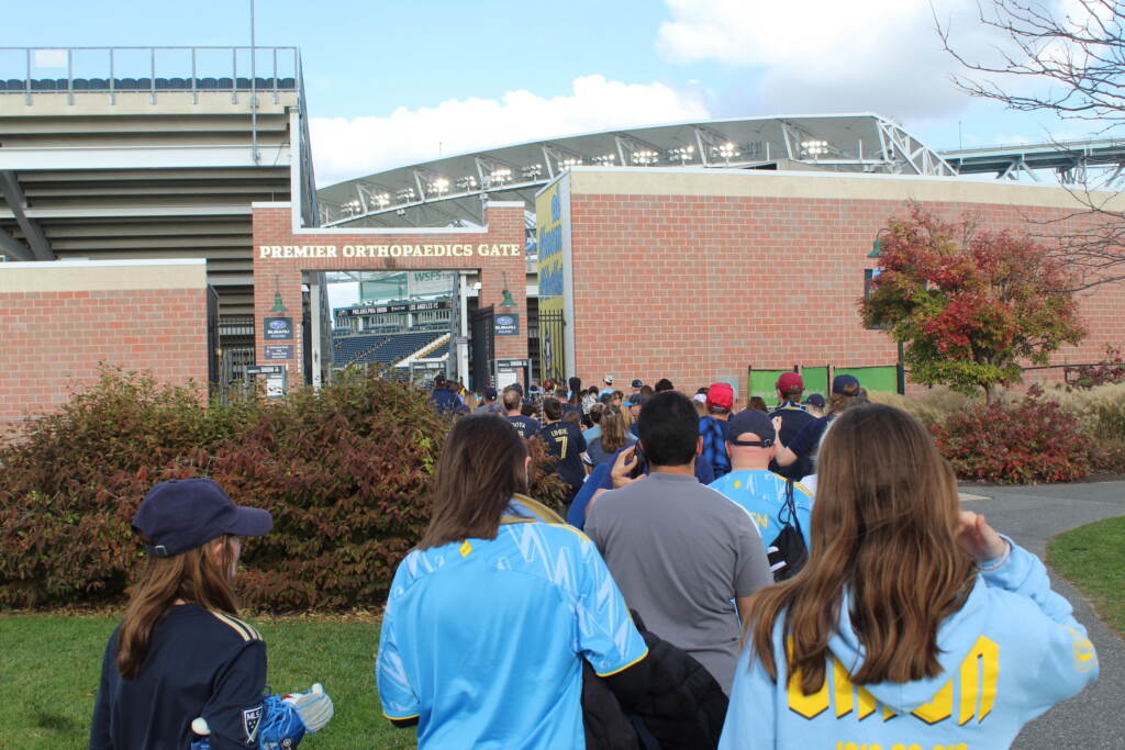 People stand outside of a stadium.