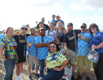 A group of people wearing Philadelphia Union jerseys pose for a photo.