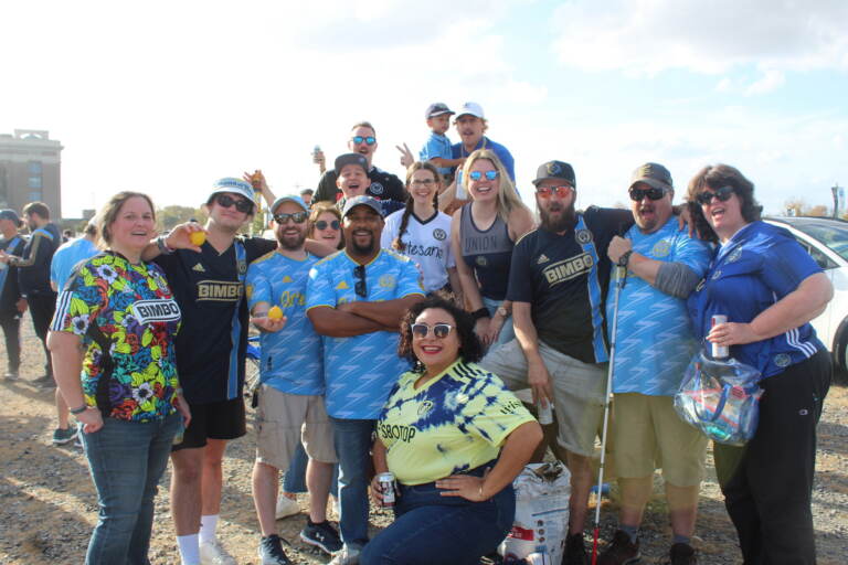 A group of people wearing Philadelphia Union jerseys pose for a photo.