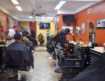 People cut hair inside of a barbershop.