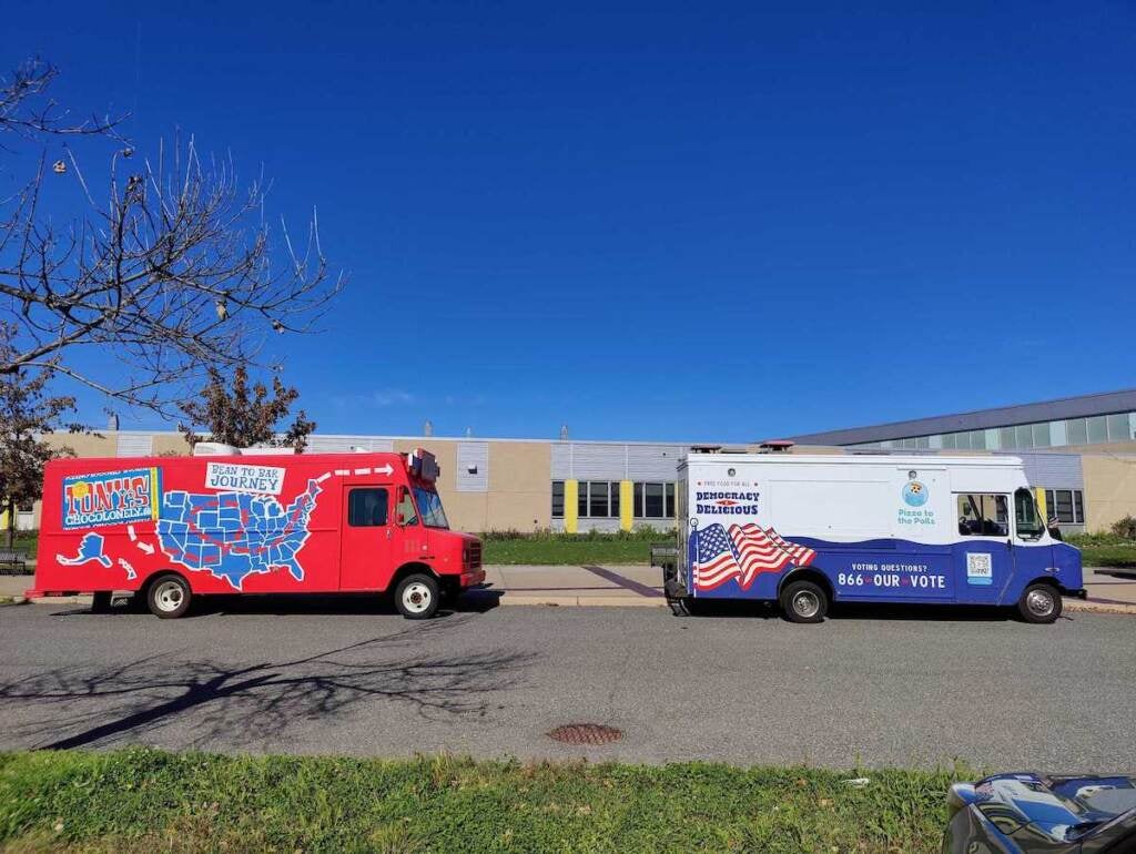 A pizza truck is parked on a sidewalk.