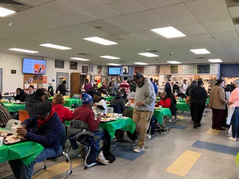 People gather around tables in a big room.