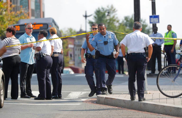 A group of police officers gathered on a street corner.