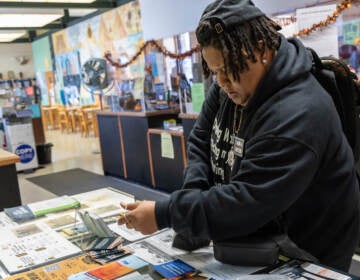 Di Hargrove, an ACLU community ambassador, hands out 'Know Your Rights' pamphlets and many other resources at and around the the Cecil B. Moore Library in North Philadelphia. (Kimberly Paynter/WHYY)