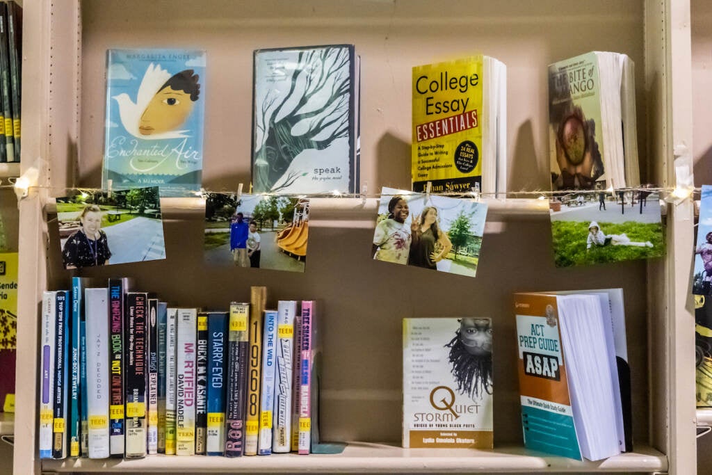Books and photos are displayed on library shelves.