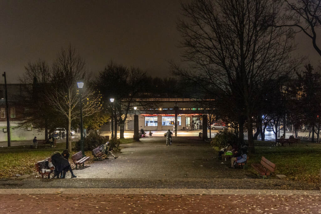 People sit on benches in a park.