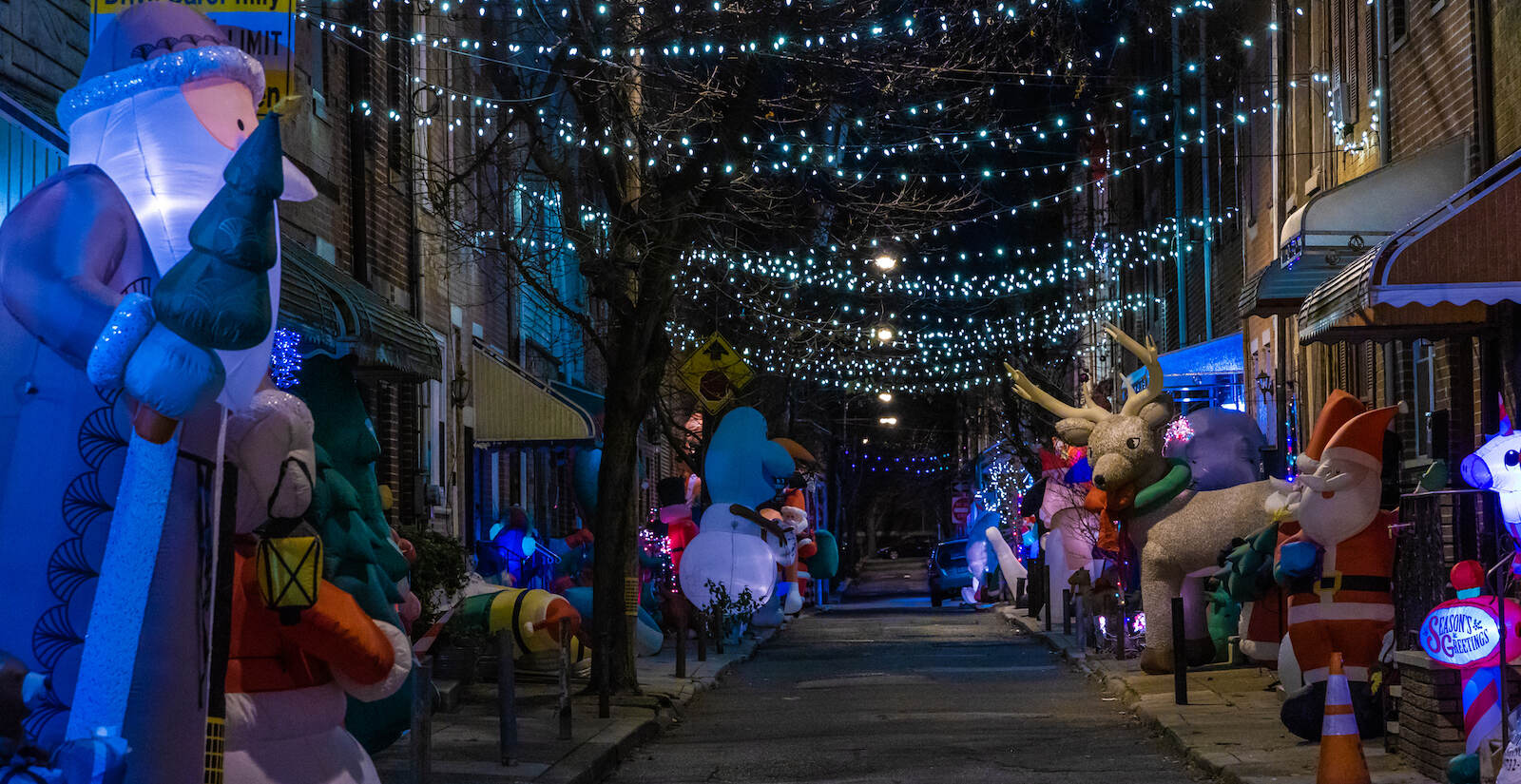 Holiday lights are strung between rowhouses in South Philly