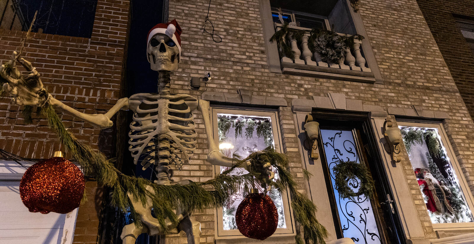 A large skeleton wearing a Christmas cap is seen outside a Philly rowhouse